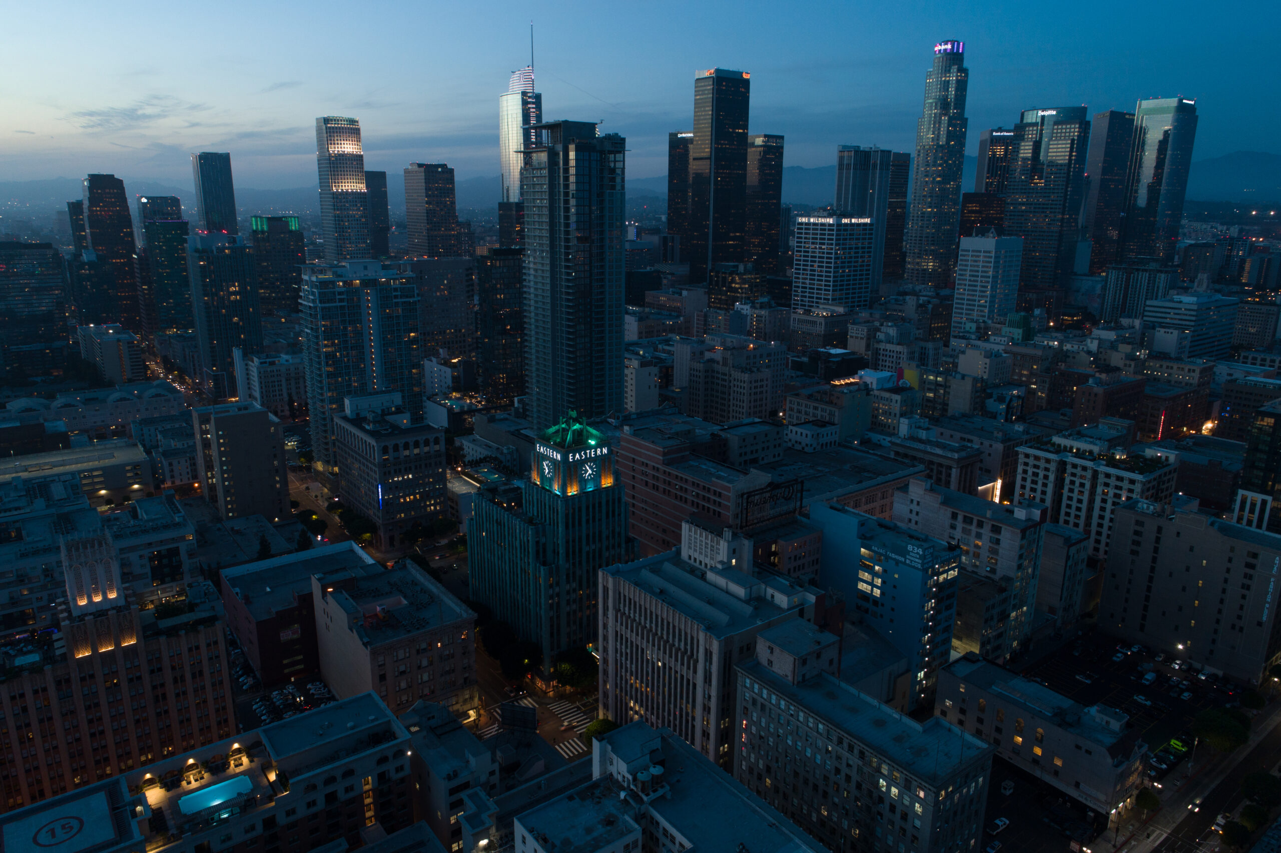 A stunning blue hour aerial shot of Downtown Los Angeles overlooking the Eastern skyline with clear blue skies.