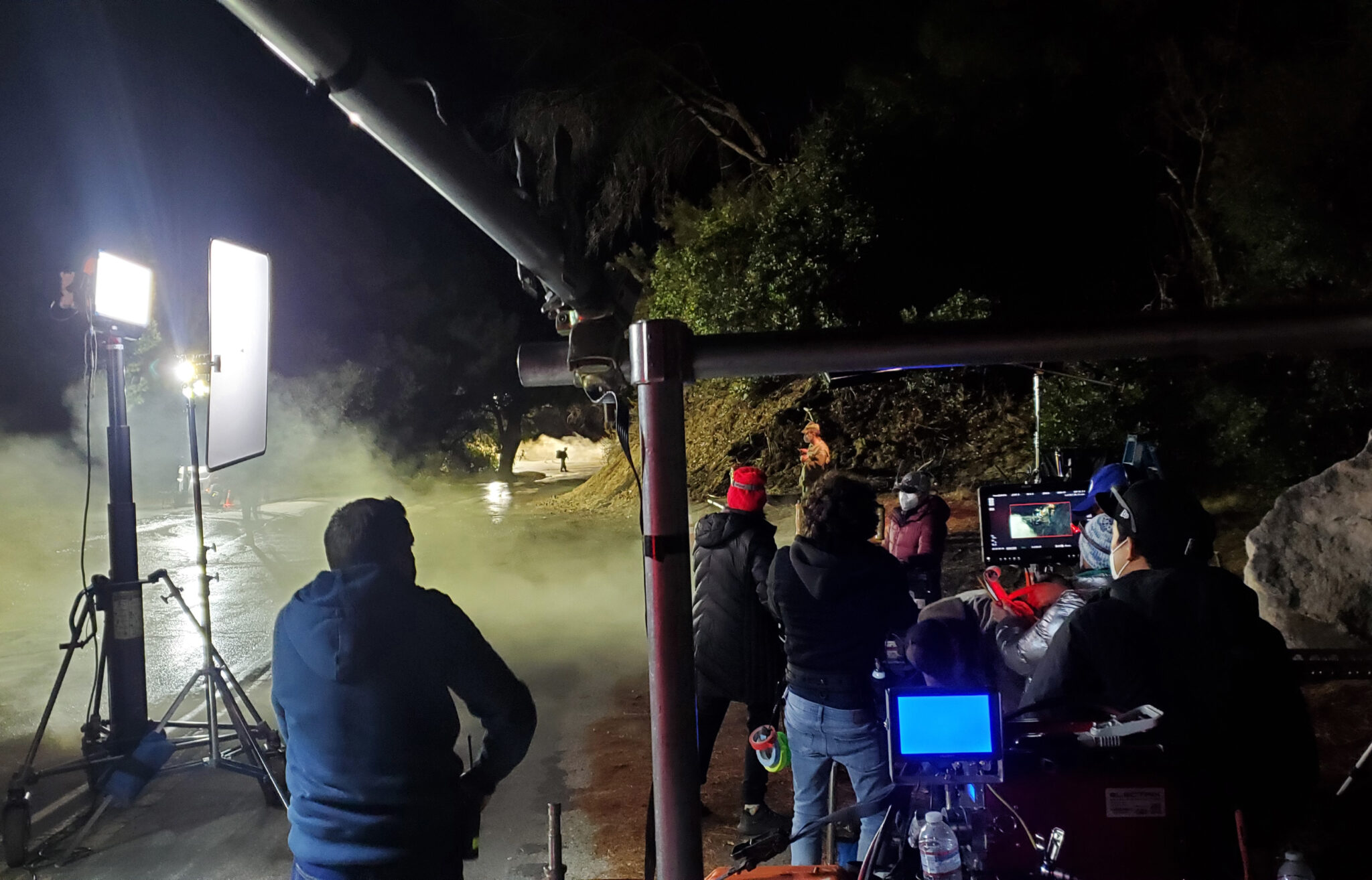 A behind-the-scenes shot of the Berry Law Super Bowl commercial at night, featuring the crew, background lights, and soldiers running by for the scene.