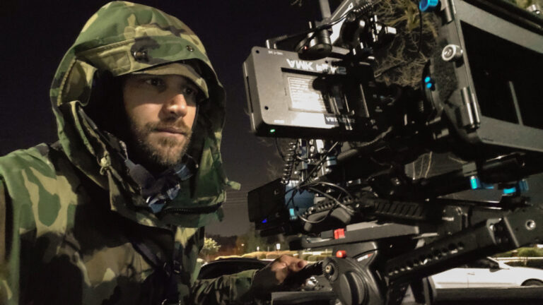 Aaron M. Kahn, director and cinematographer, reviews the last shot on the camera during a Tobacco Motorwear shoot featuring a Harley-Davidson motorcycle. The behind-the-scenes moment captures Aaron's focus and attention to detail, with the iconic motorcycle and rugged Tobacco Motorwear gear setting the tone for this dynamic production.