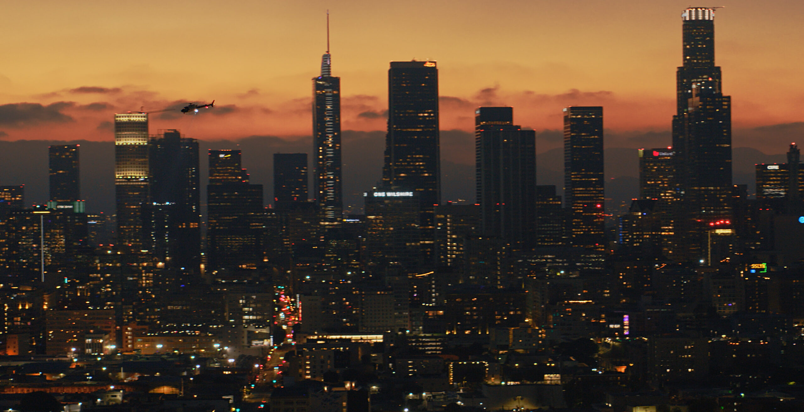 Compelling film still captured by AMK Films, showcasing a Police Department helicopter in pursuit in downtown Los Angeles.