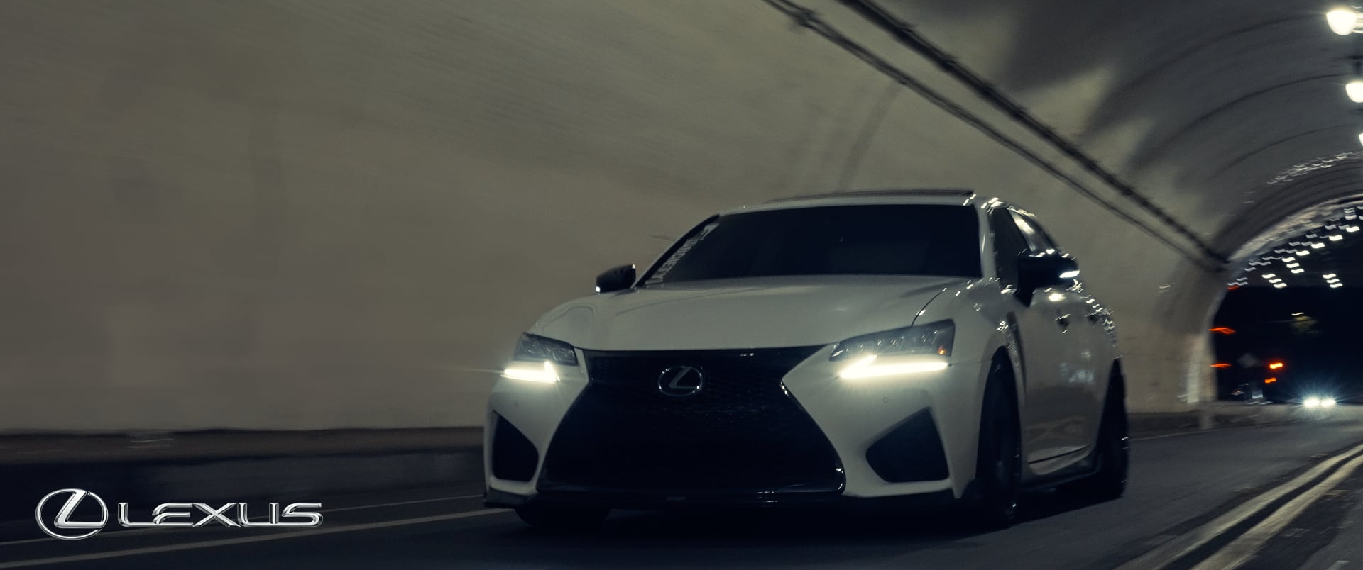 The Lexus GSF cruising through the illuminated streets of Downtown Los Angeles, showcasing its sleek design and high-performance capabilities. The vibrant city lights reflect off the vehicle's polished exterior, while dynamic camera angles and aerial drone shots emphasize its power, technology, and elegance.